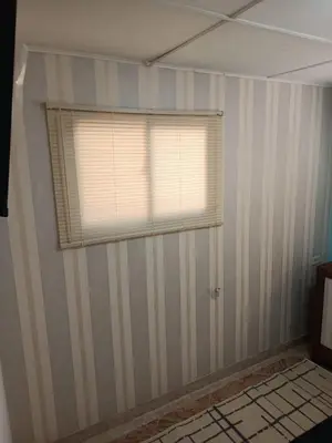 a room with a striped wall with a window at Beach Airport House in Cartagena de Indias