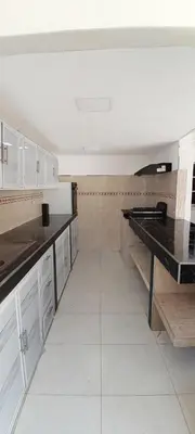a kitchen with white cabinets and a black counter top at Villa Roy in Santa Marta