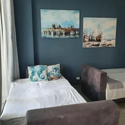 a bedroom with a bed and a couch and paintings at Luxurious, modern apartment in Cartagena Morros 3 in Cartagena de Indias