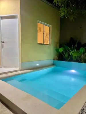 a blue swimming pool in a room with a door at Casa Agarj in Santa Marta