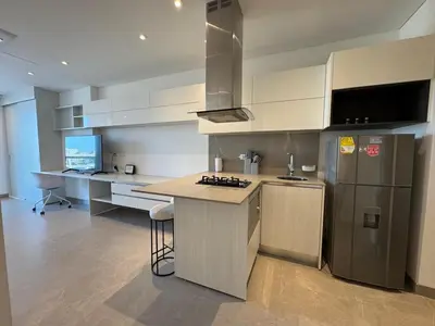 a kitchen with white cabinets and a stainless steel refrigerator at Hermosa y Comoda Suite en Distrito 90 in Barranquilla