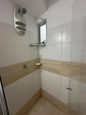 a shower with a glass door and a window at Comfortable 2 bedroom apartment with pool in Miramar in Barranquilla