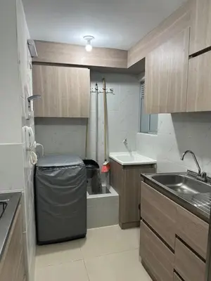 a small kitchen with a sink and a trash can at Comfortable 2 bedroom apartment with pool in Miramar in Barranquilla