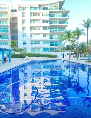 a swimming pool in front of a large building at Apartamento vista al mar cartagena Edificio Morros in Cartagena de Indias