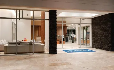 a lobby with a couch and people walking into a building at Moderno, vista al mar, AC, Wifi200MB,5Min Aeropuerto in Estación El Salto