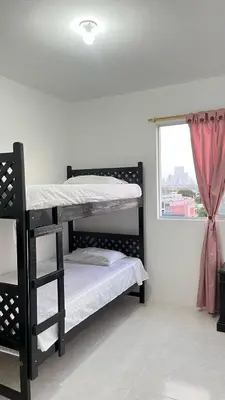 a bedroom with two bunk beds and a window at Alojamiento cerca del centro histórico y de la playa in Estación El Salto