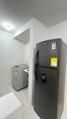 a black refrigerator in a room with a wall at Alojamiento cerca del centro histórico y de la playa in Estación El Salto