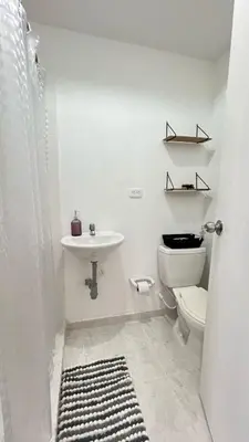 a white bathroom with a sink and a toilet at Alojamiento cerca del centro histórico y de la playa in Estación El Salto