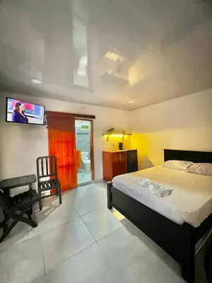 a bedroom with a bed and a tv on the wall at Sol de Coveñas Caracol in Guayabal