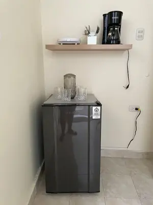 a small black refrigerator with glasses on top of it at Casa Estela in Cartagena de Indias