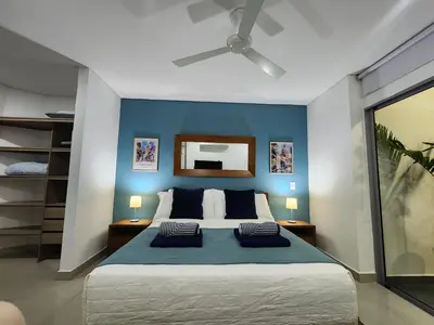 a bedroom with a bed with a blue wall at Bocagrande bay view gym jacuzzi pool in Cartagena de Indias