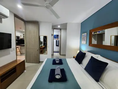 a bedroom with a large bed with a blue wall at Bocagrande bay view gym jacuzzi pool in Cartagena de Indias