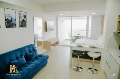 a living room with a blue couch and a table at Modern Apartasuit Cartagena Beach in Cartagena de Indias