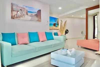 a living room with a blue couch and a table at Exclusivo apartamento de lujo frente al mar en Los Morros, con acceso directo y privado a la mejor playa de Cartagena in Cartagena de Indias