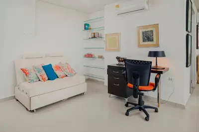 a living room with a couch and a desk and a chair at Beachfront Condo in Cartagena in Cartagena de Indias