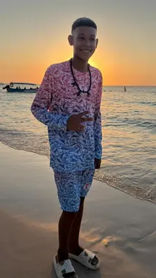 a young boy is standing on the beach at Hotel Los Chamos Barú in Cartagena de Indias