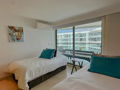a bedroom with two beds and a large window at Hotel Radisson Residences Ocean Pavillion in Cartagena de Indias