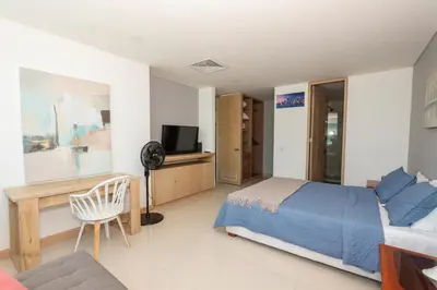 a bedroom with a bed and a desk and a tv at Bluegardens Apartment, Central with Beautiful View in Barranquilla