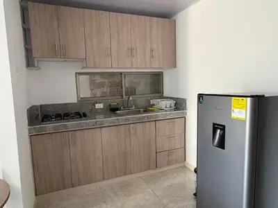 a kitchen with wooden cabinets and a stainless steel refrigerator at Maru apartamentos in Cartagena de Indias