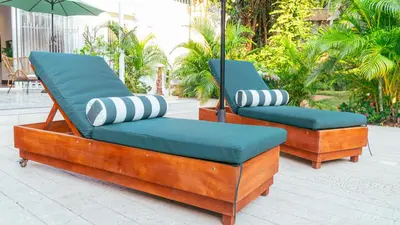 two lounge chairs with pillows and an umbrella on a patio at Casa Niza - Colonial house in Cartagena de Indias