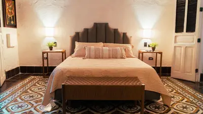 a bedroom with a large bed and two night stands at Casa Niza - Colonial house in Cartagena de Indias