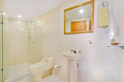 a white bathroom with a toilet and a sink at Espectacular vista piso 20 in Cartagena de Indias