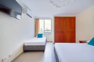 a hotel room with two beds and a tv at Espectacular vista piso 20 in Cartagena de Indias
