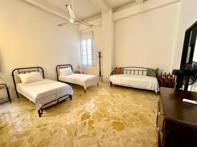 a room with two beds and a ceiling fan at by Calamari Homes - El Porvenir 306 walled city in Cartagena de Indias