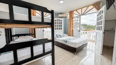a bedroom with two bunk beds and a balcony at Hotel Santiago de Tolú in Santiago