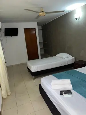 a hotel room with two beds and a tv at Stay Mar y Playa House in Cartagena de Indias