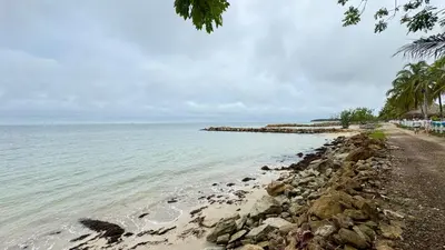 a beach with a rocky shore and the ocean at Cabaña Costa de Oro in San Antero