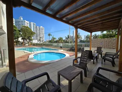 a patio with chairs and a swimming pool at Moderna suite con balcón a pasos de la playa in Cartagena de Indias