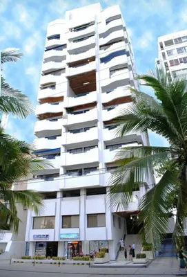 a tall white building with palm trees in front of it at aprtamento CTG in Cartagena de Indias