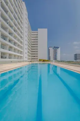 a swimming pool in front of a large building at Modern apartment near the airport in Cartagena de Indias