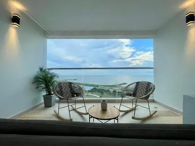 a room with two chairs and a table and a large window at Modern apartment near the airport in Cartagena de Indias