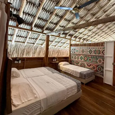 two beds in a room with a wooden ceiling at Rincón del Mangle in San Onofre