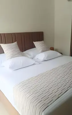 a large white bed with white pillows on it at Vista impresionante y cama king en Baia Kristal in Los Arrayanes