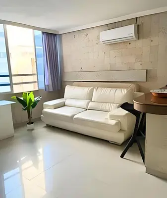 a living room with a white couch and a table at Lindo Apartstudio en El Laguito in Cartagena de Indias