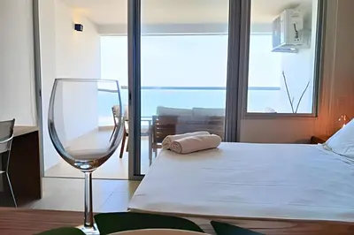 a bedroom with a bed and a wine glass at Lujoso Apart Studio frente al Mar in Cartagena de Indias