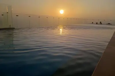 a infinity pool with the sun setting in the horizon at New Gem, 2B, 4 blocks from Center Amazing Views in Cartagena de Indias