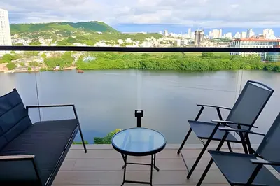 a balcony with chairs and a view of the water at Luxury 2B, stunning View 4 Blocks from walled City in Cartagena de Indias