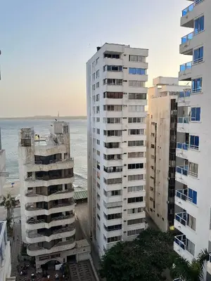two tall buildings with the ocean in the background at Apto a pasos de la playa, ubicación perfecta in Cartagena de Indias