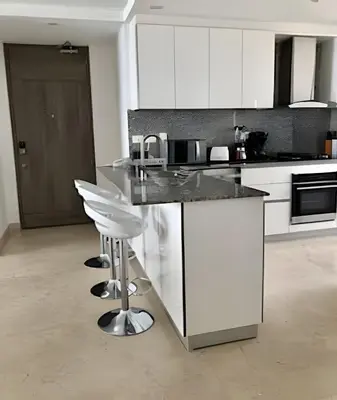 a kitchen with white cabinets and a black counter top at Breathtaking ocean view, central location in Cartagena de Indias