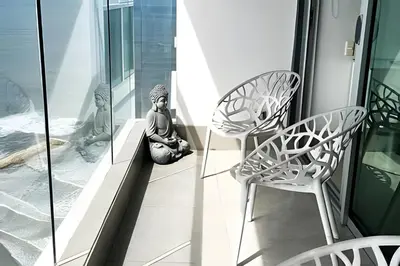 a woman sitting on a balcony with two chairs at Ocean Majesty, Luxury Haven close to Walled City in Cartagena de Indias