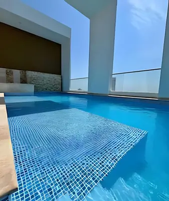 a swimming pool with blue water in a building at Charming Loft near the Beach in Cartagena de Indias