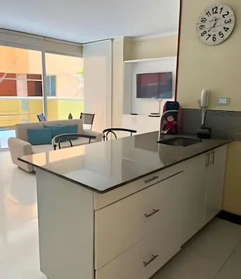 a kitchen with a counter and a clock on the wall at Lindo apto con salida directa a la playa in Cartagena de Indias