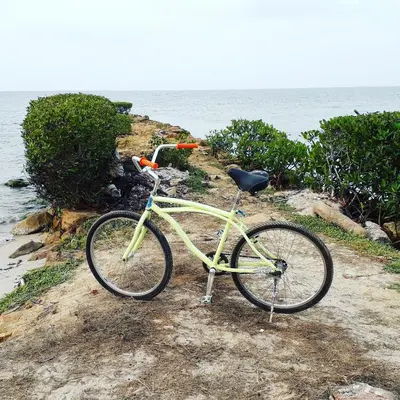 a yellow bike parked on the beach near the water at Monkey Afro Hostel in San Antero