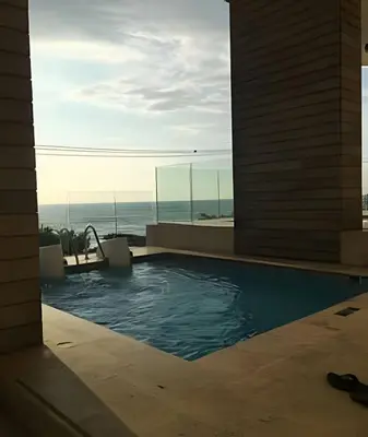 a swimming pool with a view of the ocean at Coastal Charm with Mesmerizing Seaside Views in Cartagena de Indias