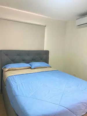 a bedroom with a bed with blue pillows on it at Bello apartamento con acceso directo a la playa in Cartagena de Indias