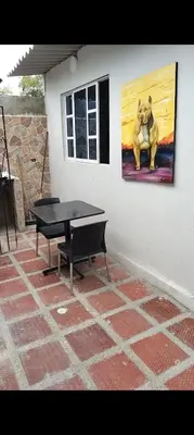 a table and a painting of a dog on a wall at Backhouse gallery in Cartagena de Indias
